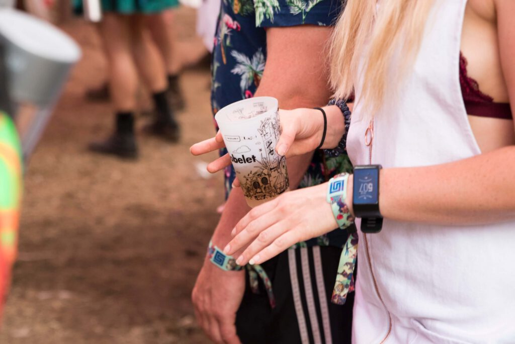 dwie kobiety, które bawią się na koncercie, festiwalu. Na nadgarstkach mają opaski tyvek z personalizowanym nadrukiem.
